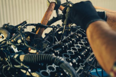 Tamirci tamirhanedeki araba motoru tamir ediyor.