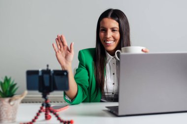 Mutlu gülümseyen uzaktan kumandalı bilgisayarlı çalışan kadın.