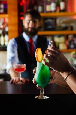 Barmen barda müşteriye kokteyl servisi yapar.