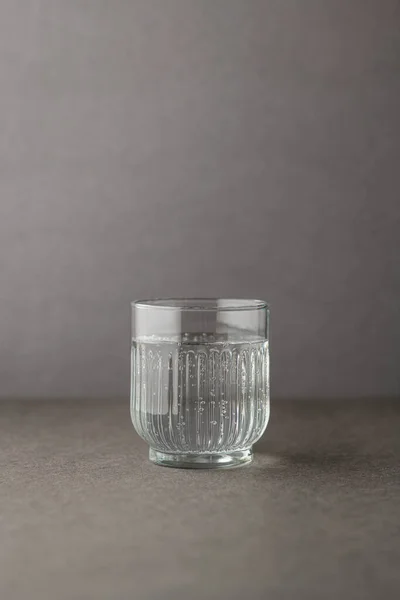 Kaynak suyu gri bir arka plan ile cam