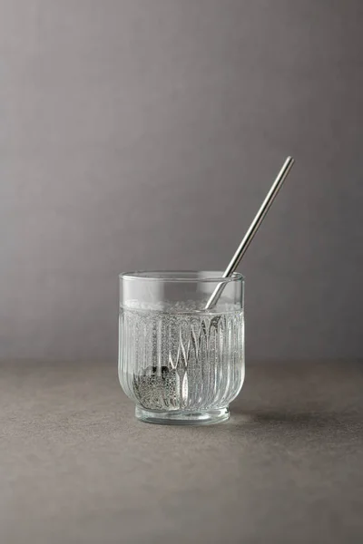 Glas Met Bronwater Tegen Een Grijze Achtergrond — Stockfoto