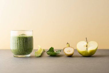 Lezzetli bir bardak detoks suyu (smoothie) ve renk arkaplanındaki malzemelerle kompozisyon