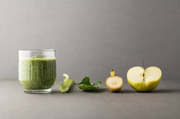 Lezzetli bir bardak detoks suyu (smoothie) ve renk arkaplanındaki malzemelerle kompozisyon