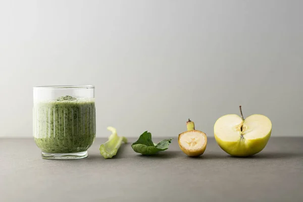 Lezzetli bir bardak detoks suyu (smoothie) ve renk arkaplanındaki malzemelerle kompozisyon