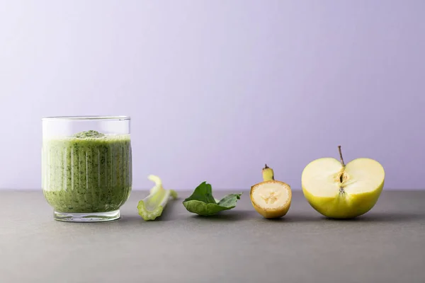 Lezzetli bir bardak detoks suyu (smoothie) ve renk arkaplanındaki malzemelerle kompozisyon