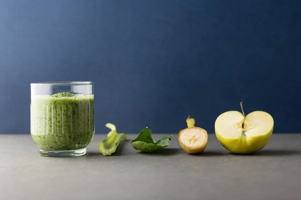 Lezzetli bir bardak detoks suyu (smoothie) ve renk arkaplanındaki malzemelerle kompozisyon
