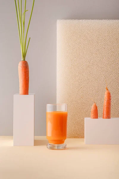 Minimalist kompozisyon ve bir bardak taze havuç suyu.