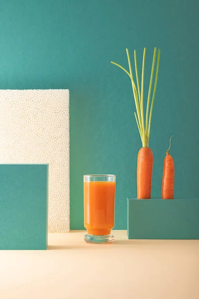 Minimalist kompozisyon ve bir bardak taze havuç suyu.