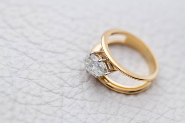 Gold Engagement Diamond Ring on White Leather Background
