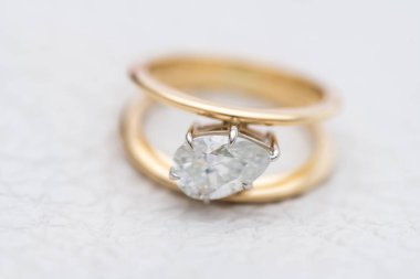 Gold Engagement Diamond Ring on White Leather Background