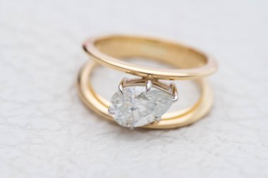 Gold Engagement Diamond Ring on White Leather Background