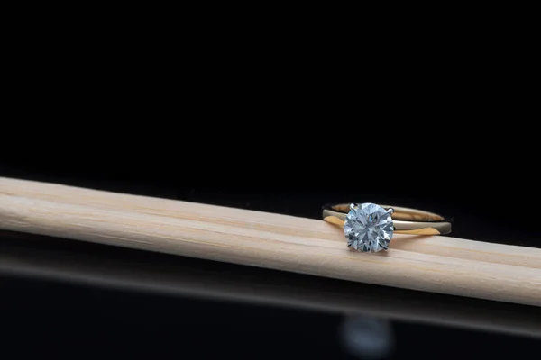 Solitaire Engagement Ring With Diamond on Wooden Chopsticks