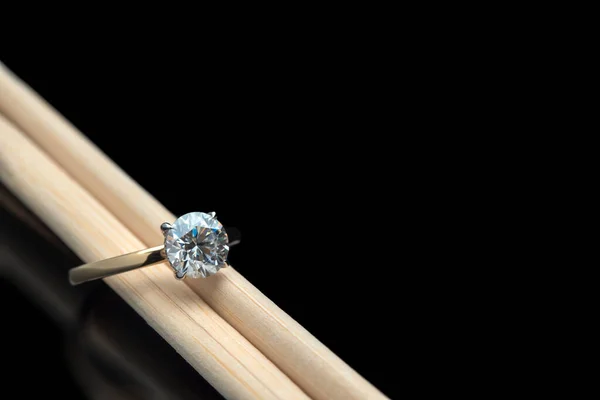 Solitaire Engagement Ring With Diamond on Wooden Chopsticks