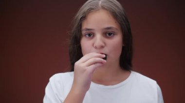 Kahverengi Arkaplanda Kurabiye Yiyen Beyaz Kız