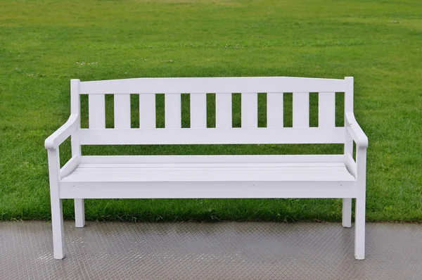 White bench on green grass Royalty Free Stock Photos