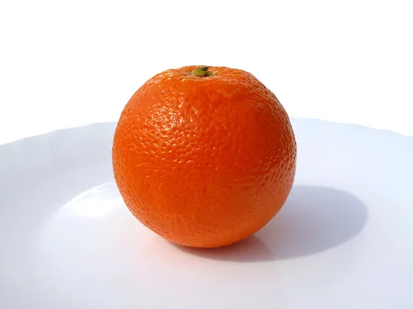 Ripe orange on white plate — Stock Photo, Image