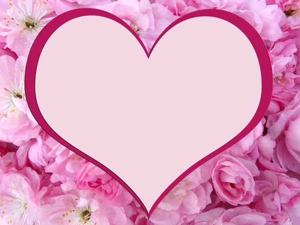 Hart op de achtergrond van roze bloemen — Stockfoto