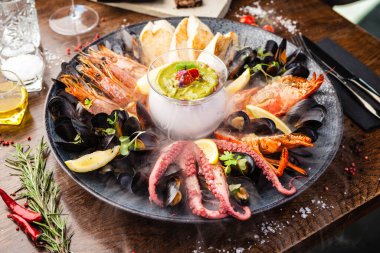 2-4 kişi için deniz ürünleri tabağı. Istakoz, ahtapot, mavi midye, Arjantin kral karidesi, ton balığı. Modern gurme yemek restoranında öğle yemeği olarak sunulan lezzetli, sağlıklı geleneksel yemekler.