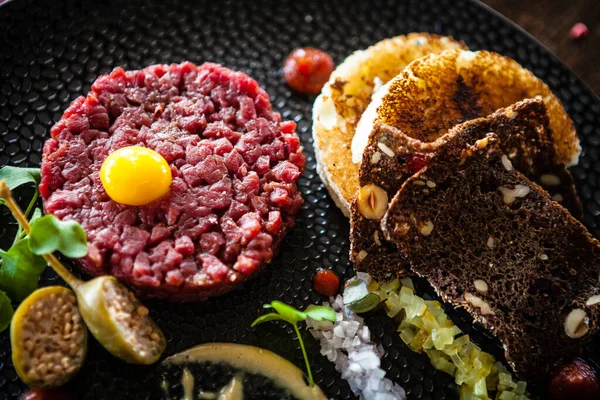 Beef tartare from Black Angus. Onion, quail egg, tomato sauce, mustard mayonnaise. Delicious healthy Italian traditional food closeup served for lunch in modern gourmet cuisine restaurant — Stock Photo, Image