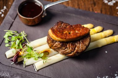 Tournedos Rossini. Foie gras, Black Angus sığır filetosu, beyaz kuşkonmaz, kırmızı şarap sosu. Modern gurme yemek restoranında öğle yemeği olarak sunulan lezzetli, sağlıklı geleneksel yemekler..