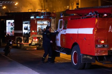 İtfaiyeciler, yol kenarında yanan bir arabayı söndürüyorlar. İtfaiyeci yol kenarındaki kazadan sonra arabadaki yangını suyla söndürüyor. Kharkov, Ukrayna, 22.10.2021
