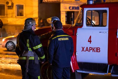 İtfaiyeciler, yol kenarında yanan bir arabayı söndürüyorlar. İtfaiyeci yol kenarındaki kazadan sonra arabadaki yangını suyla söndürüyor. Kharkov, Ukrayna, 22.10.2021