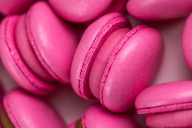 Makarnalar beyaz ahşap arka planda yakınlaşır. Tatlı ve renkli pembe Fransız badem kurabiyeleri. Evde yemek pişirmek.. 