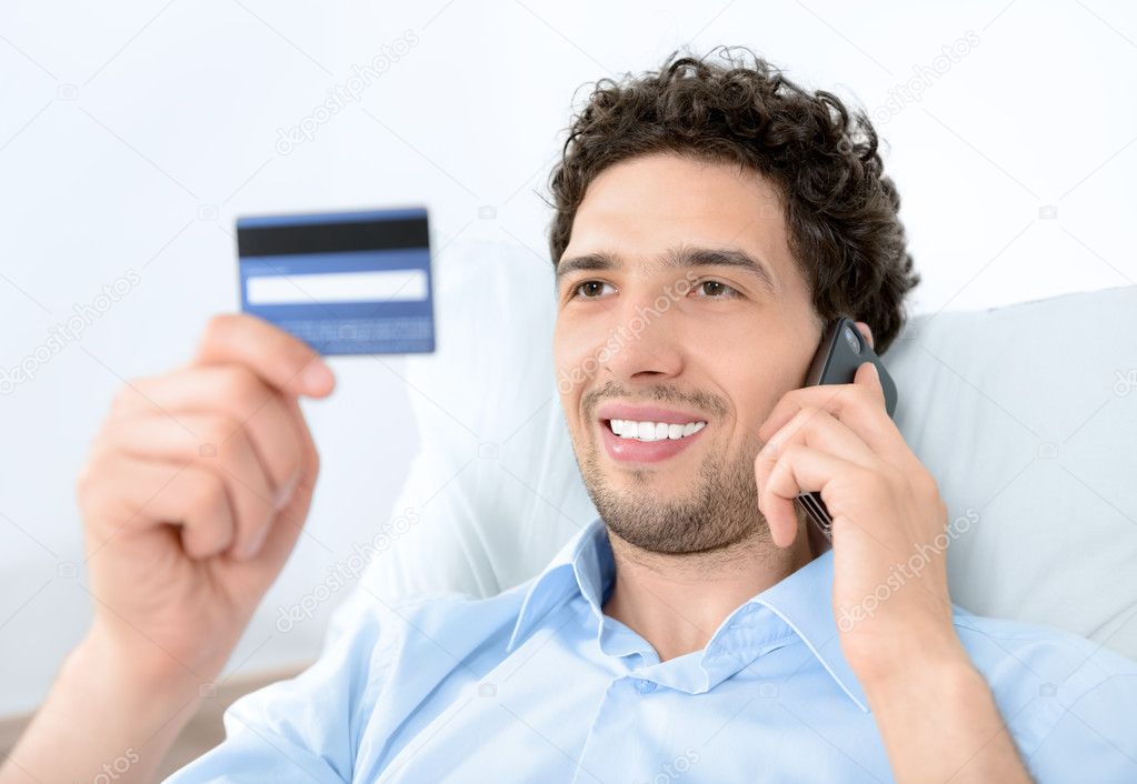Young man on mobile with credit card