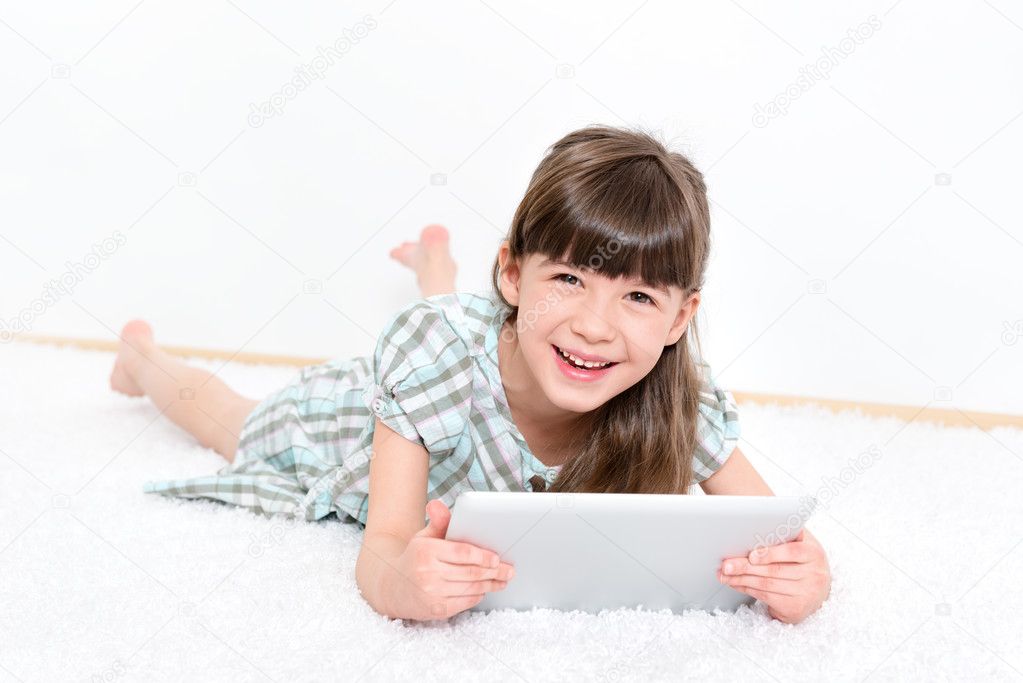 Joyful little girl with a tablet