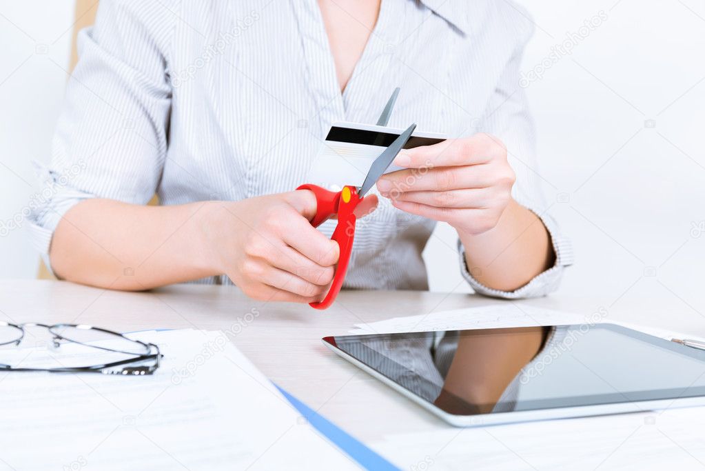 Businesswoman cutting credit card