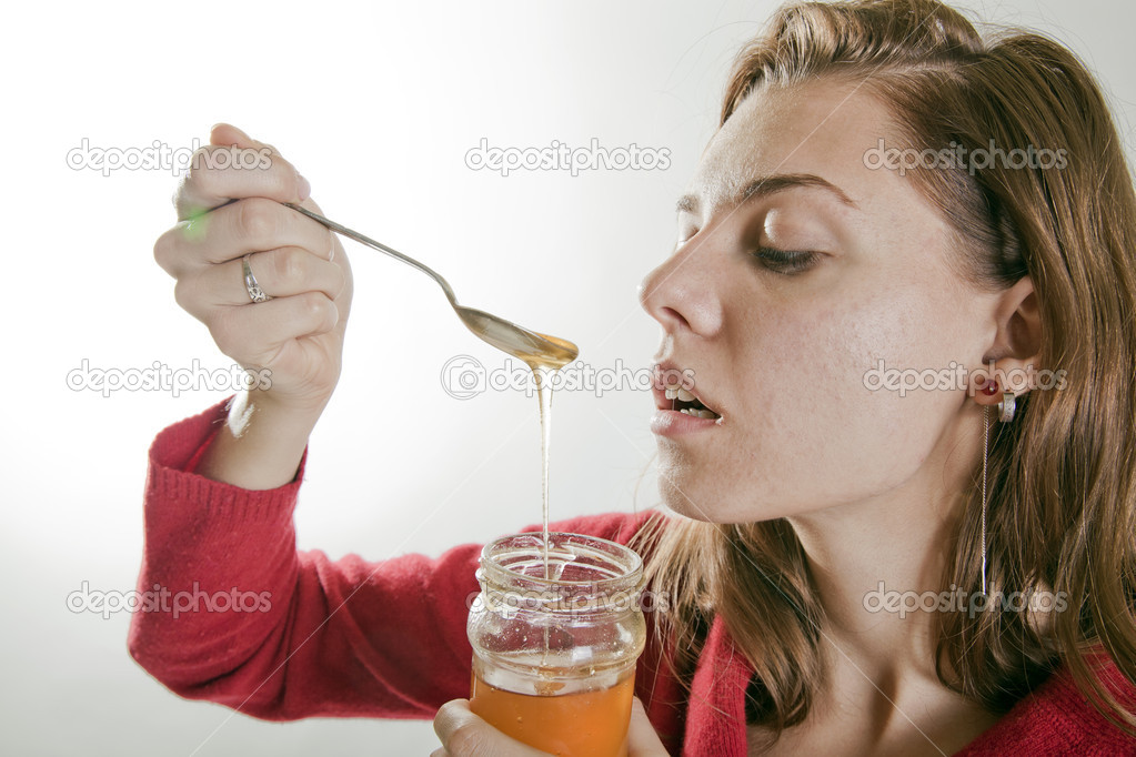 Young woman eating honey