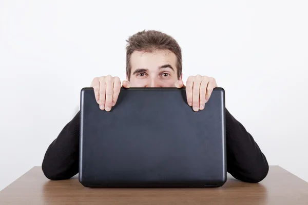 Sich hinter einem Laptop versteckt — Stockfoto