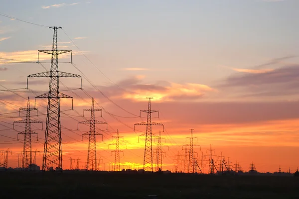 Linhas de transmissão de energia elétrica ao pôr do sol — Fotografia de Stock
