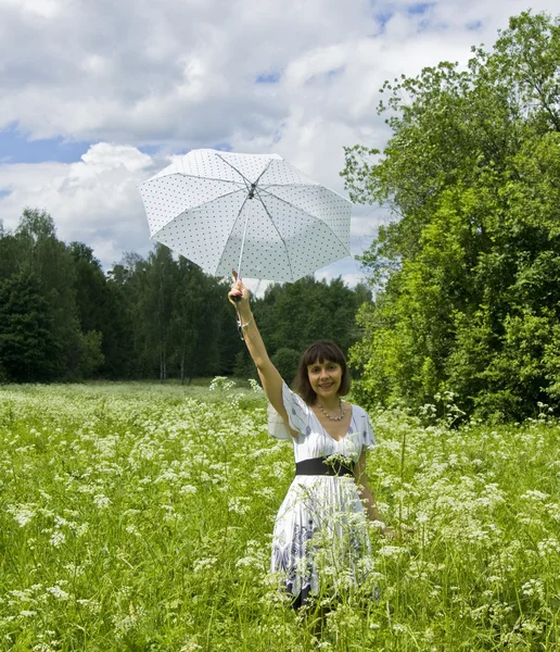 Jovem com guarda-chuva branco no prado em flor — Fotografia de Stock