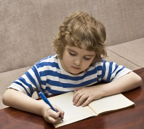 Criança escrevendo em caderno — Fotografia de Stock