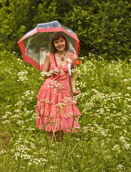 Jonge vrouw met paraplu en rode rose — Stockfoto