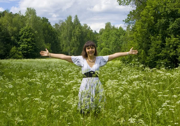 Jonge vrouw in witte jurk op een weide in bloei — Stockfoto