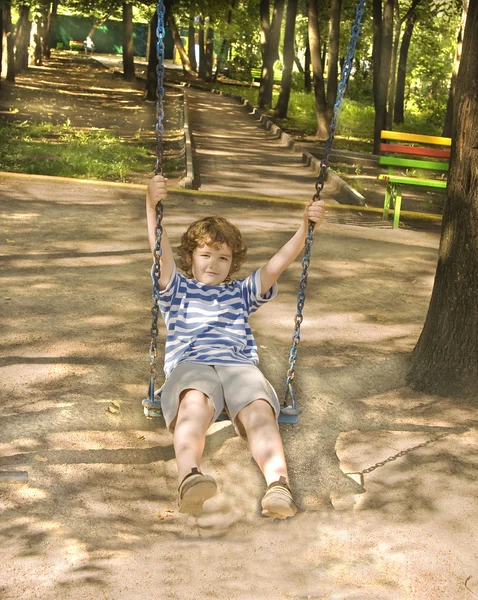 Liten pojke på gungor — Stockfoto