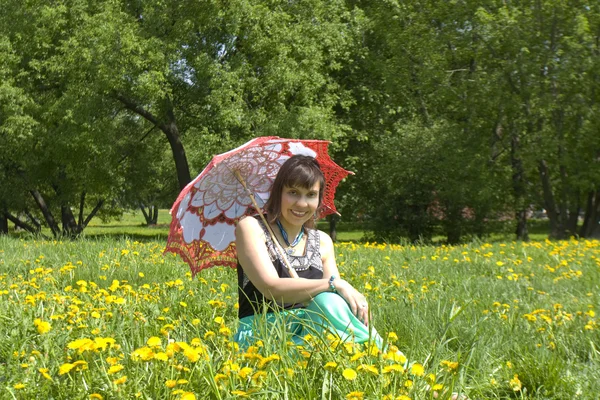 Lady with parasol and yellow dandelions — Stock Photo, Image