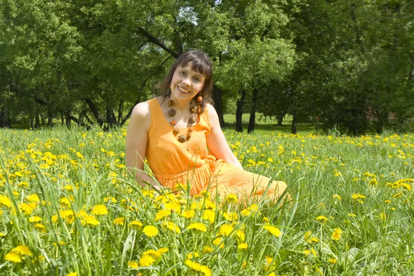 Mooie vrouw op weide met paardebloemen — Stockfoto