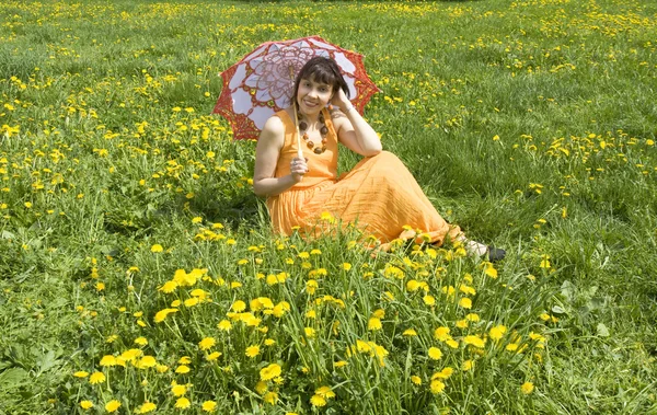 Женщина с зонтиком и желтыми одуванчиками — стоковое фото