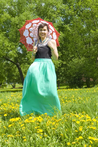 Dame met parasol op gele paardebloemen — Stockfoto