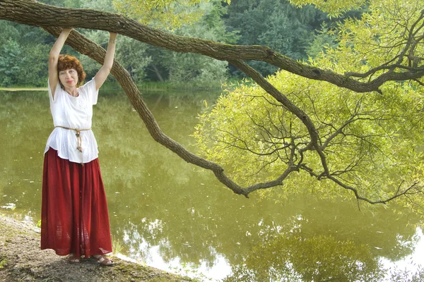 Жінка біля озера з вербою — стокове фото