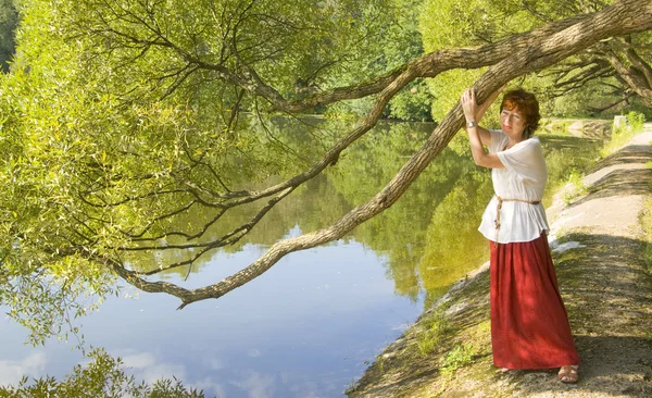 Woman with willow tree and lake — Stock Photo, Image