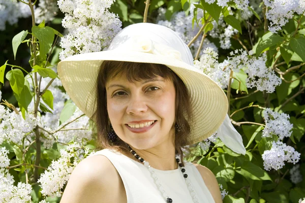 Señora de sombrero con flores lila —  Fotos de Stock