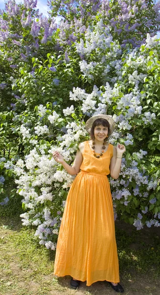 Mulher de laranja com lilás — Fotografia de Stock