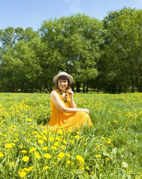 Vrouw op weide met gele paardebloemen — Stockfoto