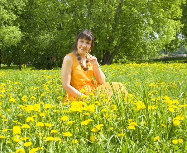 Vrouw in weiland met paardebloemen — Stockfoto