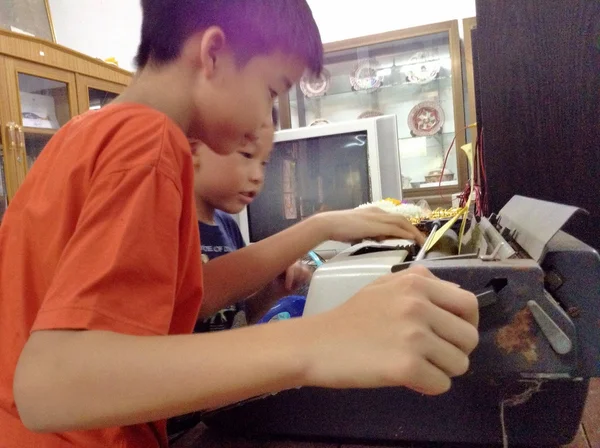 Thaise jongens leren hoe te gebruiken inktlinten voor schrijfmachines en writig machine. — Stockfoto
