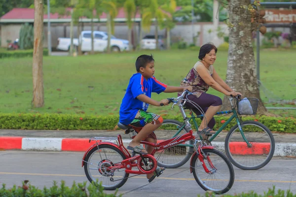 Mormor och barnbarn ridning cykel i park — Stockfoto